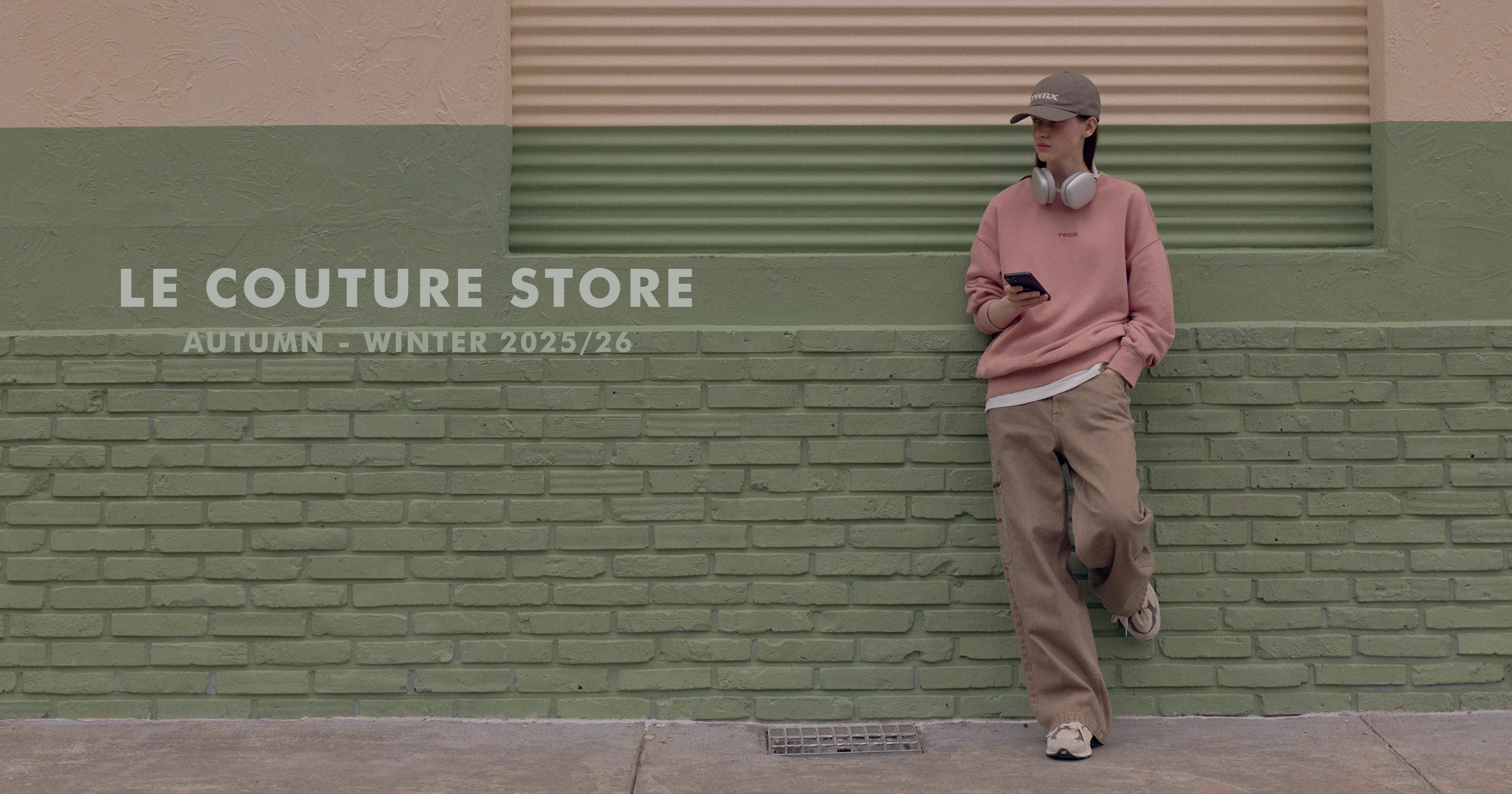 Person leaning against a green wall with 'Le Couture Store' branding