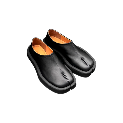 Pair of black leather shoes with orange lining on a white background