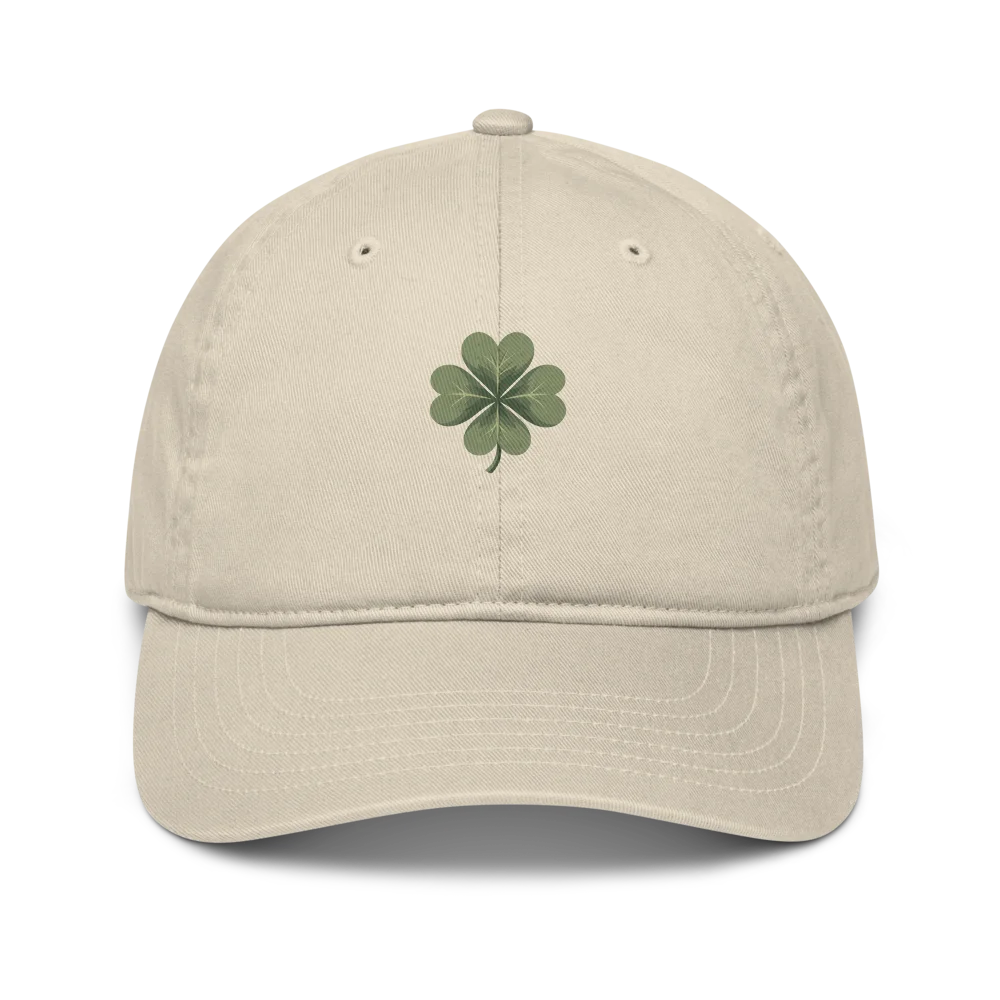 Made from 100% organic cotton in 3/1 twill. Fabric weight: 8 oz/yd² (271 g/m²). Designed as an unstructured 6-panel cap with a low profile, curved visor, matching sewn eyelets, and a self-fabric adjustable closure with a brass slider and hidden tuck-in. Finished with a muted green four-leaf clover print on the front.